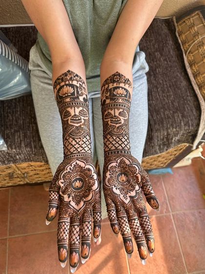 A beautiful design with a large floral mandala on the palm and traditional motifs like kalash and lotus on the arms.