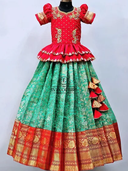 A festive red and sea green Banarasi lehenga. The blouse has a double-layered peplum, and the skirt is made of rich brocade.
