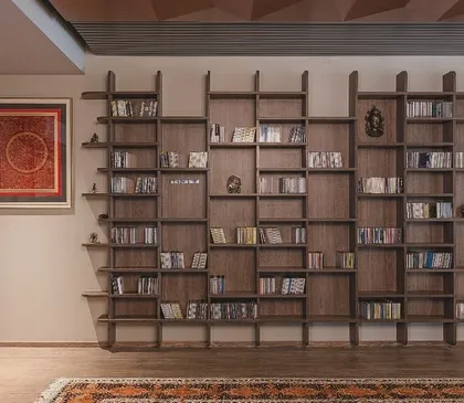 We designed this 'Library of Music' for a client with an extensive collection. The custom-built wooden bookshelf features an irregular, geometric pattern, turning a storage unit into a sculptural art piece that reflects the owner's passion.