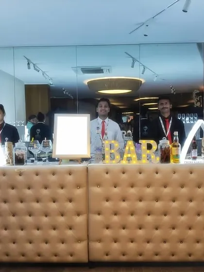 A full view of the beige tufted bar, showing its modular design that can be adjusted to fit different venue sizes.