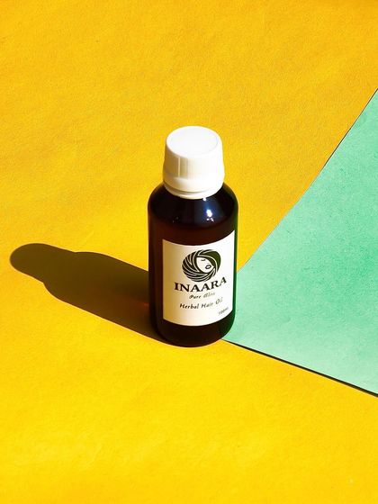 A professional shot of my Pure Bliss hair oil. This little bottle is packed with herbal ingredients to reduce hair fall, fight frizz, and improve hair texture and volume.