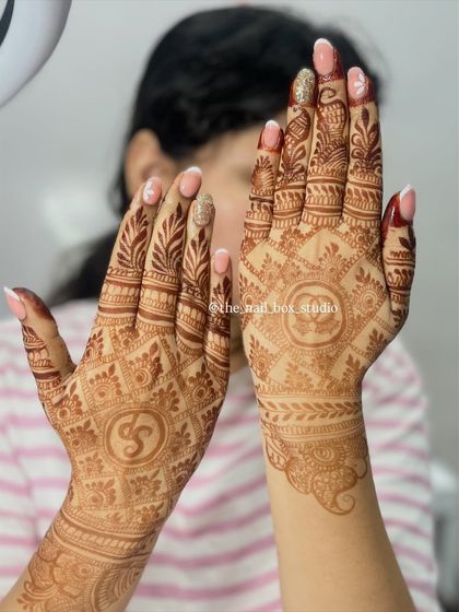A full view of this elegant bridal set. I used soft gel extensions to create a classic French manicure with a twist, adding a delicate floral design and a sparkling glitter accent nail that stands out beautifully against the mehndi.