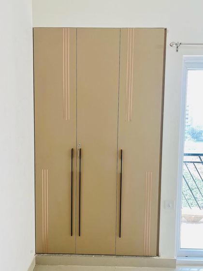A three-door wardrobe with long handles and subtle vertical grooves, offering a clean and sophisticated look.