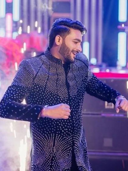 The groom looking sharp and confident during his sangeet performance. I help grooms feel comfortable on stage so they can enjoy their moment.