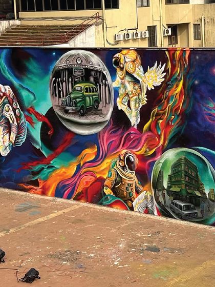 The other side of the mural, showing astronauts exploring a colorful cosmos filled with bubbles of earthly scenes, like a classic Mumbai taxi. It’s a surreal blend of the future and the present.