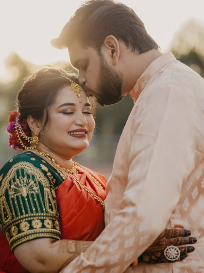 A tender moment between the couple. The bride's makeup is soft and romantic, with a focus on glowing skin and a gentle smile, perfect for these intimate shots.