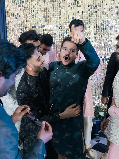 The groom's friends lifting him up and having fun on the dance floor.