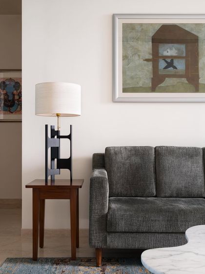 A detail of the living room sofa and a custom side table with a sculptural lamp. I believe every piece of furniture, no matter how small, contributes to the overall feeling of a room.