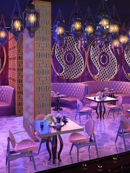 The seating area of a Dubai lounge and bar, designed with an Arabian-inspired theme. I used purple ambient lighting, tufted banquettes, and hanging lanterns to create an exotic and immersive nightlife experience.