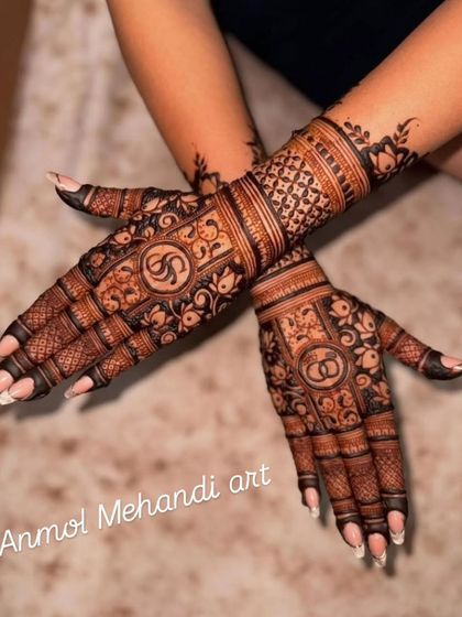 A clear view of the personalized palms, where the initials "S" and "G" are designed to be the centerpiece of the henna art.