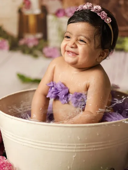 All smiles during her post-cake smash bath! The water splash session is a fun way to get clean and capture even more happy photos.