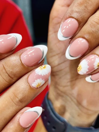 Natural nails never looked this cute. A fresh take on the French manicure with modern silver-lined tips and adorable daisy accent nails.