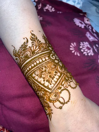 A detailed wristband or `bail` design, perfect for someone who wants an elegant touch without full coverage.