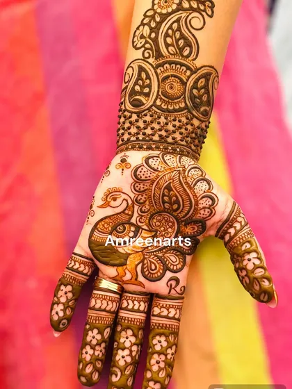 A single hand adorned with a beautiful peacock and paisley design, perfect for a bridesmaid or guest.