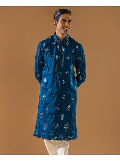 A full-length view of the teal mirror-work kurta. This smiling model showcases a look designed to make you shine, perfect for Diwali or any festive occasion.