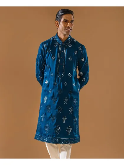 A full-length view of the teal mirror-work kurta. This smiling model showcases a look designed to make you shine, perfect for Diwali or any festive occasion.
