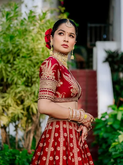 A timeless bridal portrait. I focus on capturing the bride's elegance and the intricate details of her wedding lehenga, like this stunning red Sabyasachi ensemble, creating a classic image she'll cherish forever.