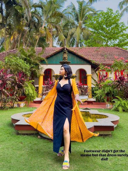 A black dress can be perfect for a vacation. Here, I've layered a bright yellow printed shrug over a simple black slit dress to add a pop of color and create a resort-ready look.