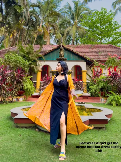 A black dress can be perfect for a vacation. Here, I've layered a bright yellow printed shrug over a simple black slit dress to add a pop of color and create a resort-ready look.