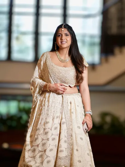 A full-length view of this understated and elegant look. The soft makeup ensures that the intricate details of her outfit and jewelry are the main focus.