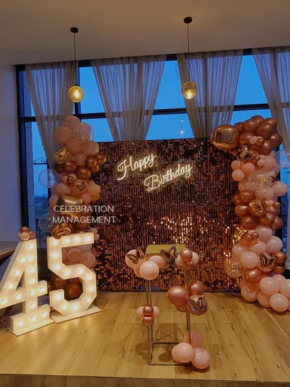 Milestone birthdays deserve a grand statement. For this 45th birthday, I created a stunning photo corner using large, light-up marquee numbers against a rose gold shimmer wall, framed by a matching balloon garland.