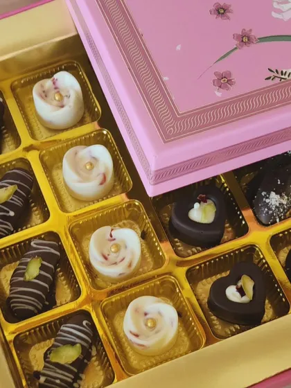 Our artisan chocolates are a popular choice for corporate Diwali gifting. This elegant pink box contains a selection of handcrafted dark, white, and milk chocolates with fillings like pistachio and rose, offering a sophisticated and delicious festive treat.