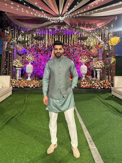 A happy client at his sister's wedding, looking sharp in a pastel green kurta paired with an embroidered jacket. It's always a pleasure to see my creations as part of your big moments.