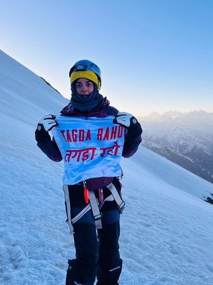 One of our earliest members, who quietly built her strength rep by rep, stands at 5000m holding our flag. Her journey is proof that what we're building is more than a workout; it's a way of being that empowers you to reach your peak.