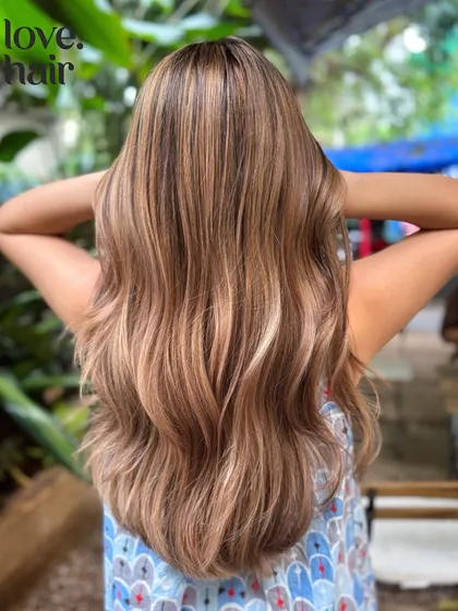 Another angle of this beautiful bronde balayage, showing how it catches the light in an outdoor setting.
