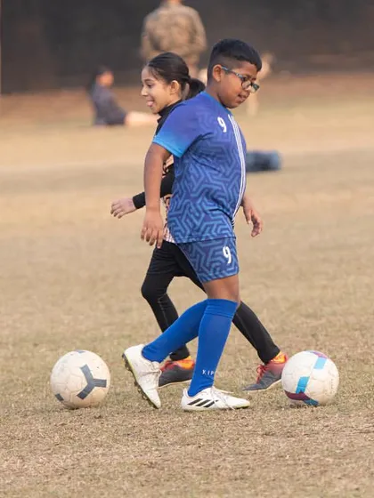 A girl and a boy competing for the ball. At DYFA, we create a co-ed training environment where everyone challenges each other to be better.