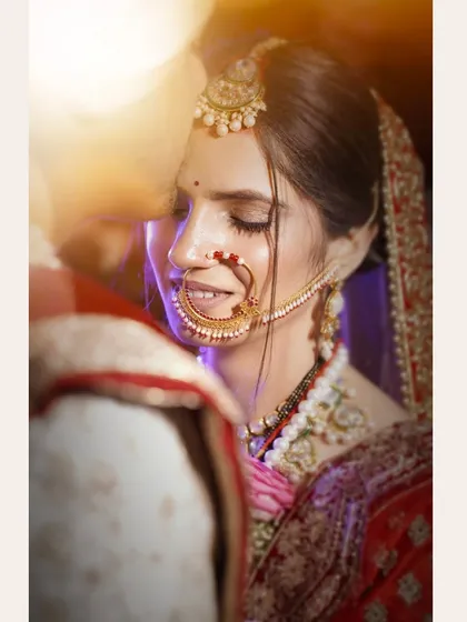 A quiet moment with the bride. I use soft lighting to highlight the intricate details of the bridal jewelry, like the traditional nath, and capture the serene happiness before the main ceremony.