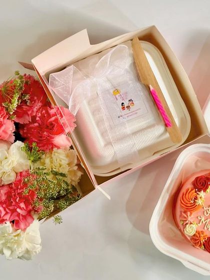 A beautiful flat-lay of our Mother's Day gift options. This includes a floral wreath bento cake and a flower box hamper, showcasing the elegant and coordinated gifting possibilities.