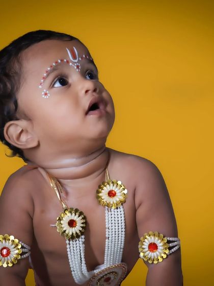 A beautiful profile shot of a baby during a 'Little Krishna' shoot. His upward gaze gives the photo an angelic and divine quality, perfectly fitting the theme.