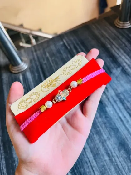 A closer look at the Hamsa hand charm bracelet, showing the intricate details and pearl accents.