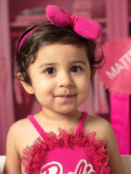 A series of close-up portraits showing the many adorable and happy expressions of a little girl during her Barbie-themed session.