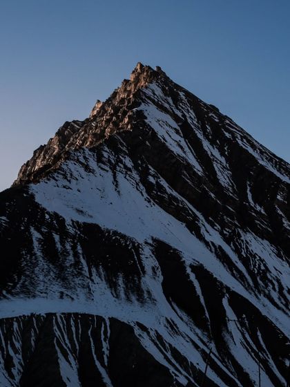 The sharp, dramatic peak of a mountain in Spiti at sunrise. I use my 70-200mm lens to isolate these details, highlighting the textures and shadows of the rugged landscape.