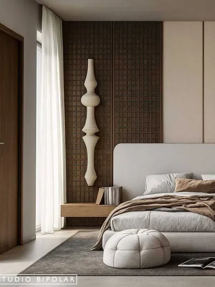 A close-up of the sculptural wall art and the textured, grid-like paneling behind the bed. The warm wood and soft white palette keeps the space feeling grounded and serene.
