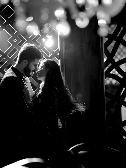 A black and white pre-wedding photo that uses shadows and light from a geometric background to create a moody and artistic silhouette of the couple.