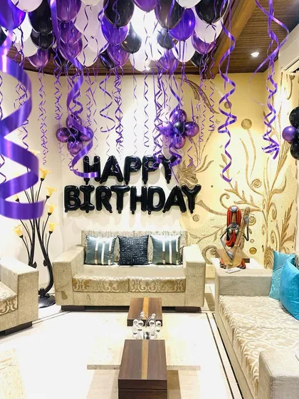 A wider view of the living room birthday decoration. This shows how we use ceiling balloons with hanging ribbons to transform a regular home space for a celebration.