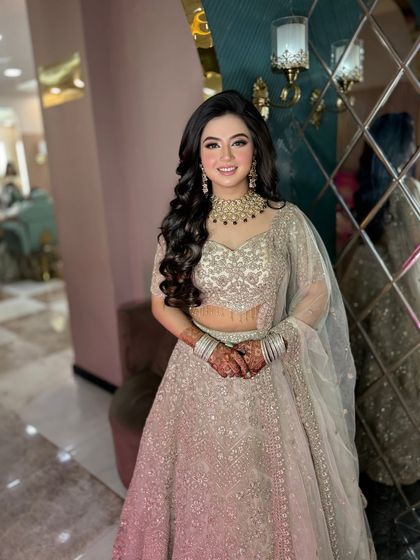 A full-length view of this beautiful look. The soft glam makeup is the perfect choice for her elegant, shimmering lehenga.