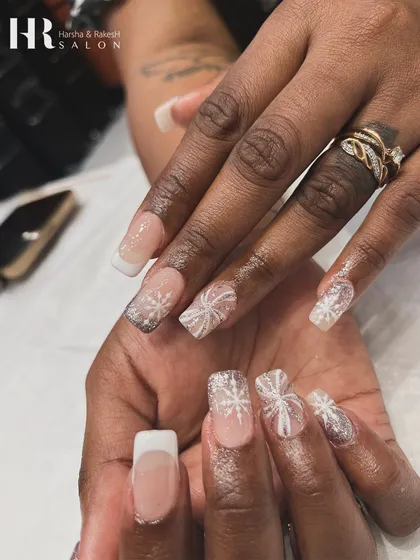 Celebrate the festive season with nails that sparkle. This design combines a classic French manicure with glittery snowflake art, creating a magical, winter-themed look perfect for the holidays.