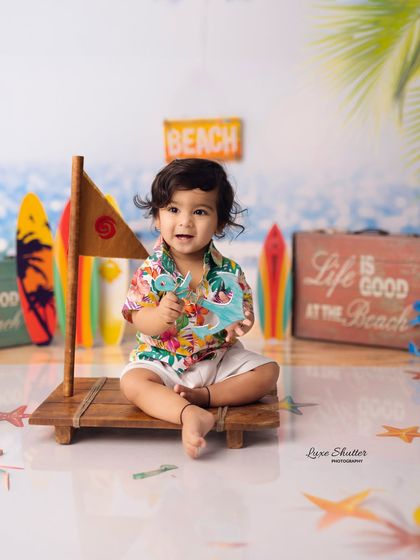 Another adorable shot from our beach theme, capturing the baby's sweet and curious expression as he plays with the props.