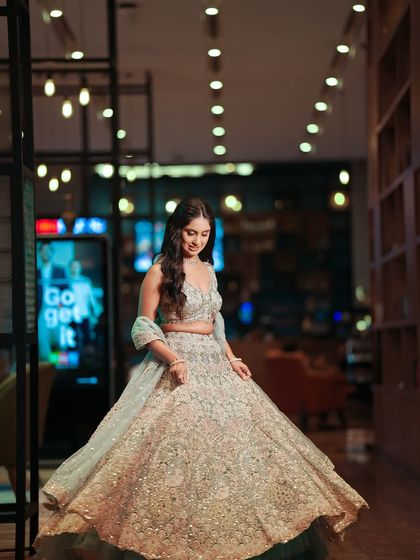 A full-length shot of the bride in her stunning reception lehenga. The soft, glowing makeup is the perfect finishing touch.