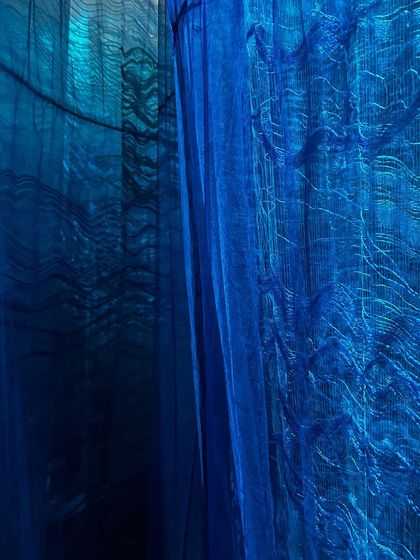 A detail of the deep blue, custom-woven textiles from the 'Into The Deep' installation. The texture and color allude to the unfathomable, expansive, and mysterious depths of the sea.