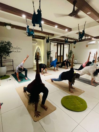 Students hold a lunge pose, their strong and stable forms filling the studio.