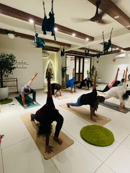 Students hold a lunge pose, their strong and stable forms filling the studio.