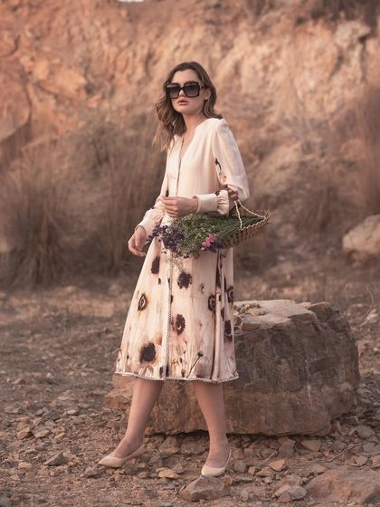 This shot shows the model holding a basket, adding a lifestyle element to the lookbook. It helps customers visualize wearing the dress for a day out.