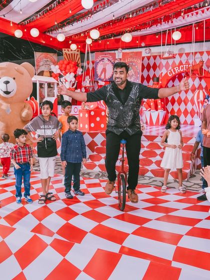 A performer on a unicycle engages with the young guests. I select entertainment that is not only skillful but also interactive and fun for the children.