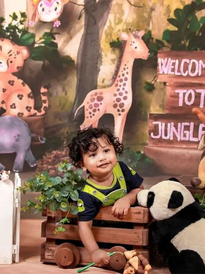 A fun 'Welcome to the Jungle' theme for a toddler. Surrounded by plush safari animals, this little explorer is ready for an adventure.