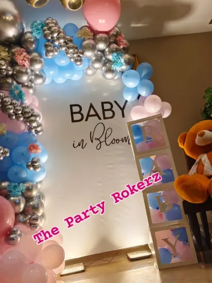 A closer look at the "Baby in Bloom" decor, showing the details of the balloon arch and the personalized "BABY" blocks.